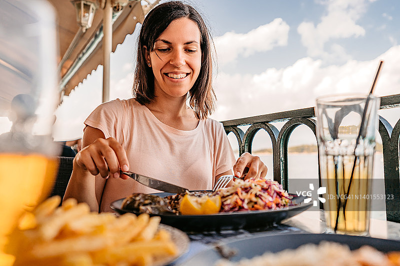 在海边享用午餐的年轻女人图片素材