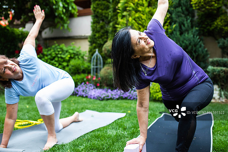 中年妇女参加使用道具的初学者瑜伽课程图片素材