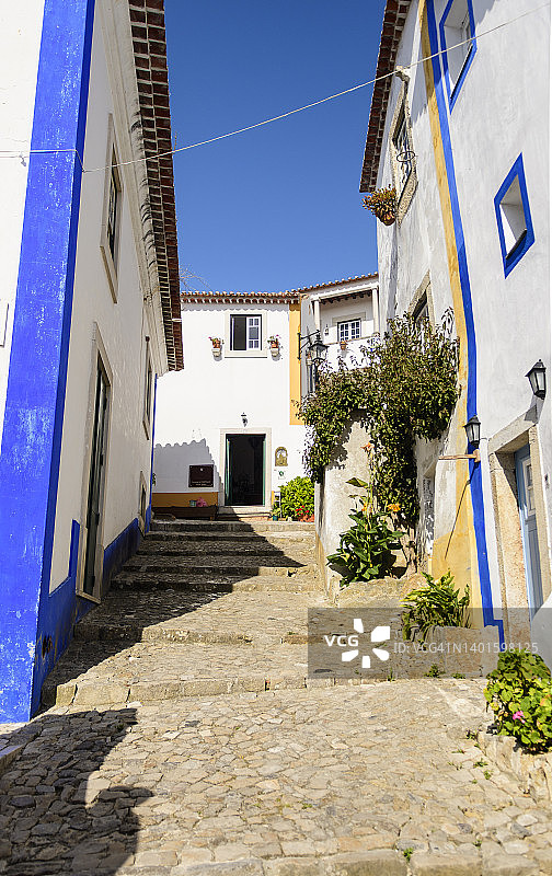 葡萄牙奥比多斯中世纪鹅卵石台阶小巷和白色房屋图片素材