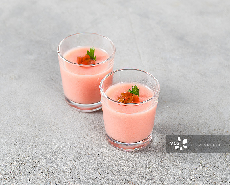 玻璃杯中的番茄意式奶冻，浅灰色背景图片素材