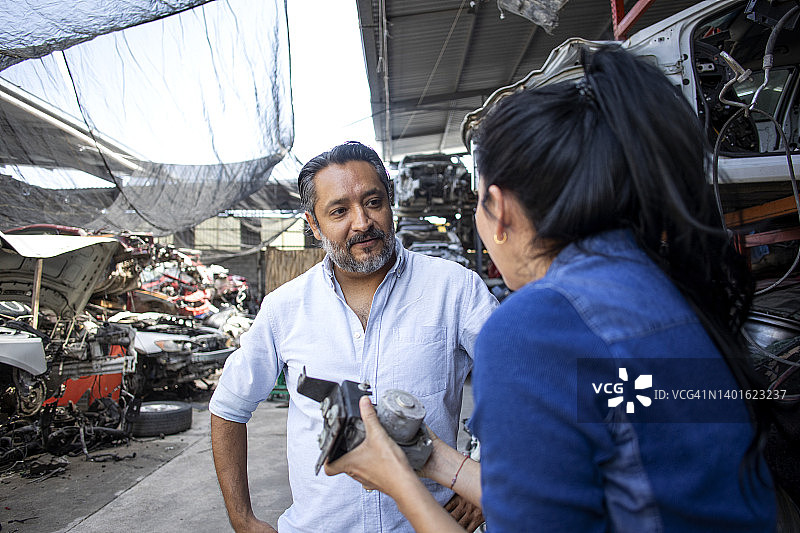 在汽车零件业务中与顾客交谈的女人图片素材