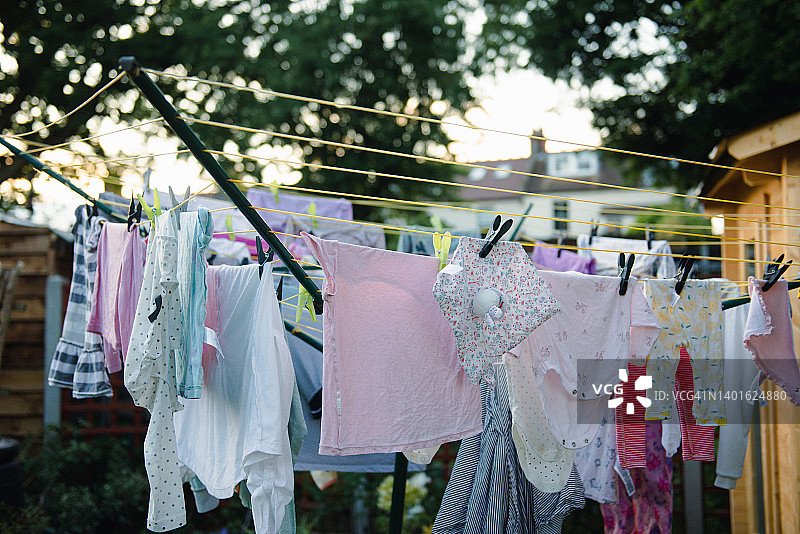 后院草地上旋转晾衣绳上晾晒的衣服图片素材