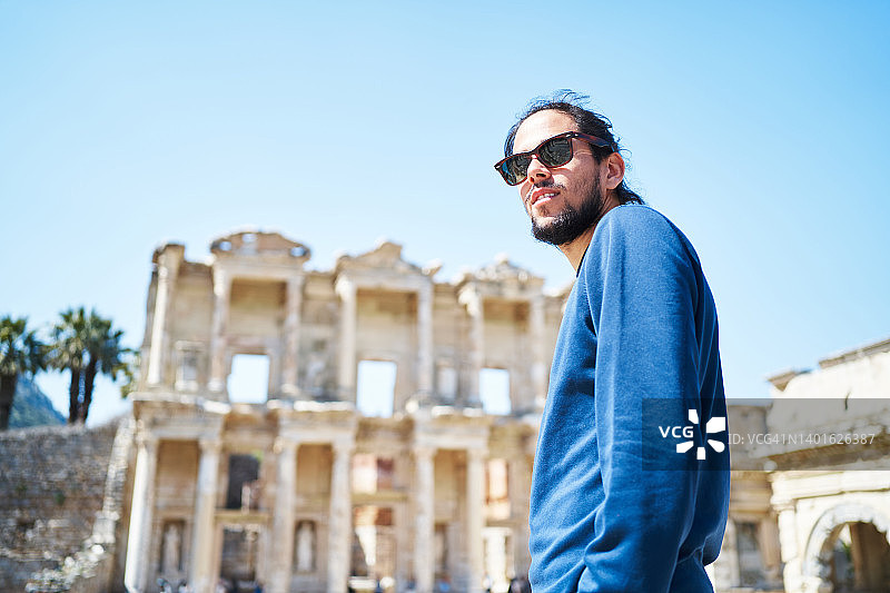 严肃的少数民族旅行者探索古代以弗所城，晴空万里图片素材