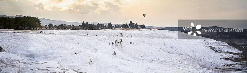 日落时分飞越石灰华梯田的热气球图片素材