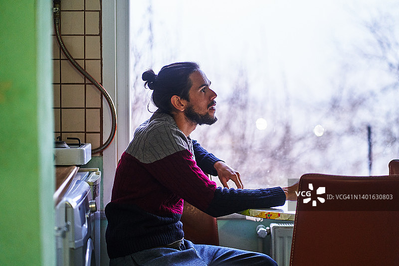 男人坐在厨房的桌子旁图片素材