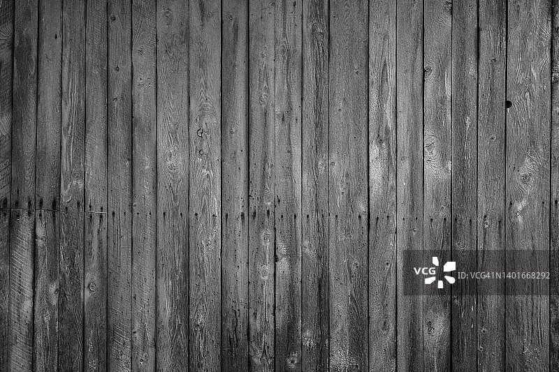 黑白照片中饱经风霜的深色木墙的正面照图片素材