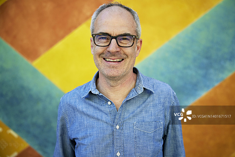 穿着牛仔衬衫的50多岁快乐男子肖像图片素材