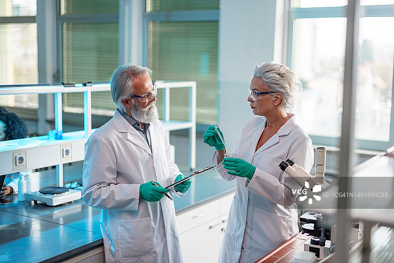 专业生物化学家讨论科学实验图片素材