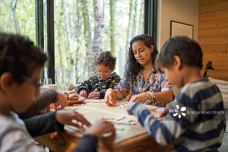 家庭在小屋的桌子上玩拼字游戏图片素材