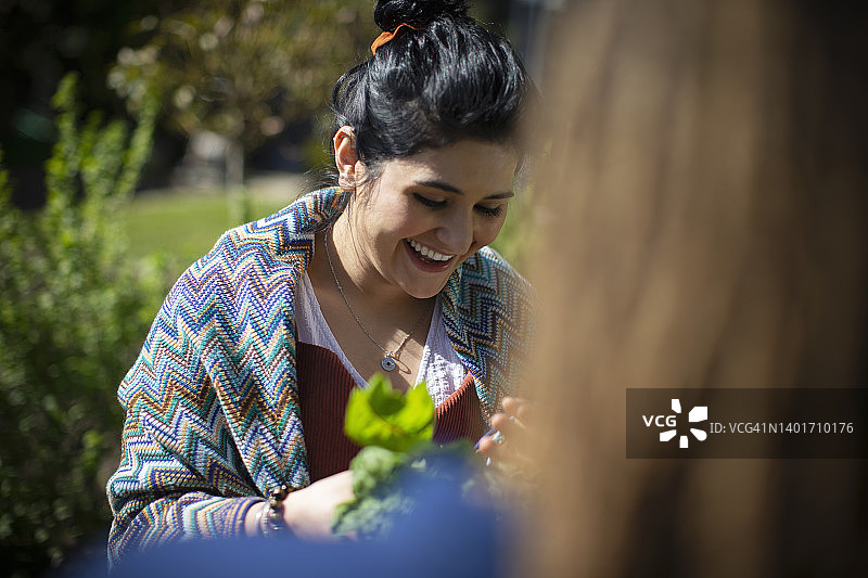 在阳光明媚的花园里的快乐年轻女子图片素材