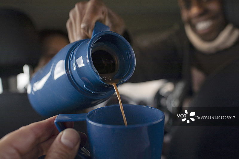 男子用保温瓶倒咖啡的POV特写图片素材