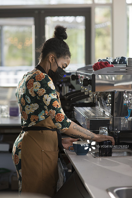 咖啡师在咖啡馆里制作拿铁的肖像图片素材