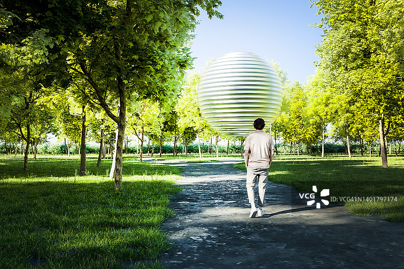 休闲男人走向公园里神秘的光球图片素材