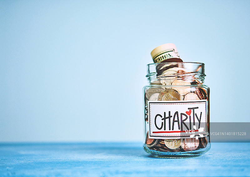 慈善捐款罐，蓝色背景，带有文字空间图片素材