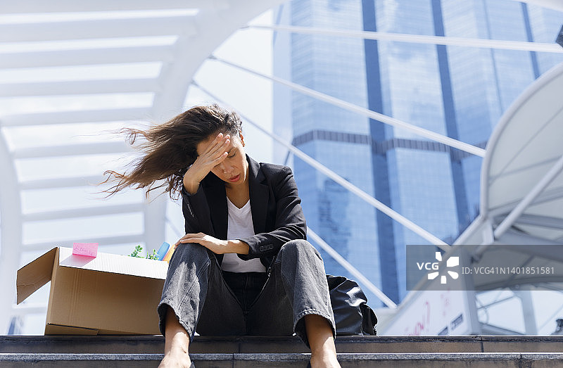 因被公司解雇而感到不快乐和悲伤的女商人。商业概念背景图片素材