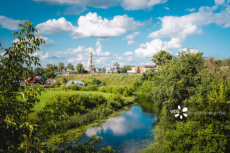苏兹达尔的夏季风景。卡缅卡河岸边的以利亚先知教堂。游客在SUP板上漂浮在河上。俄罗斯，弗拉基米尔地区，俄罗斯金环图片素材