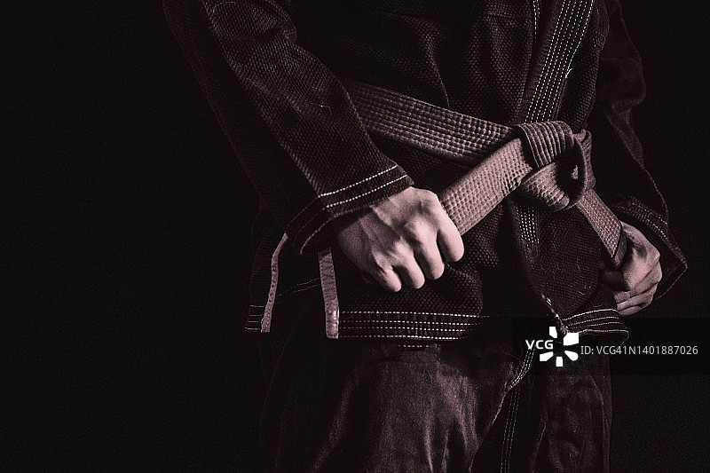 亚洲男人练习巴西柔术——手握腰带特写图片素材