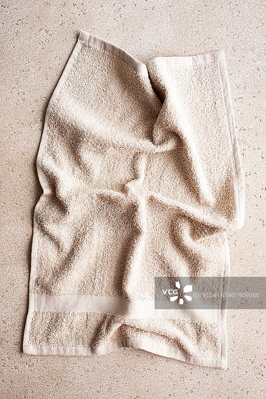 折叠米色浴巾混凝土背景俯视图特写图片素材