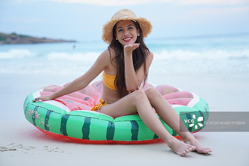 笑容灿烂的年轻女子在海滩上图片素材