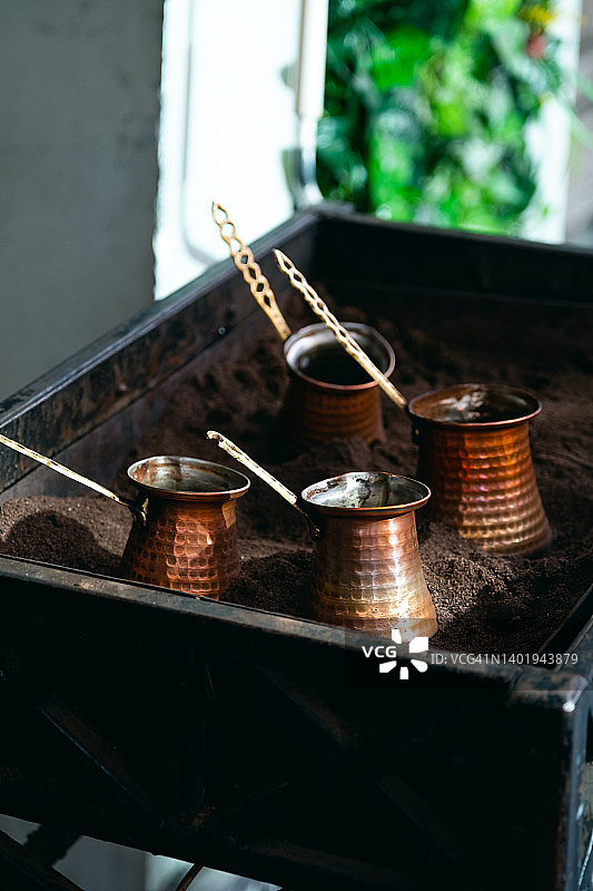 在户外街头咖啡馆的沙滩上，在土耳其的中制作咖啡的过程。金属机器人,特写。早餐的概念，咖啡休息，旅游和旅行。图片素材