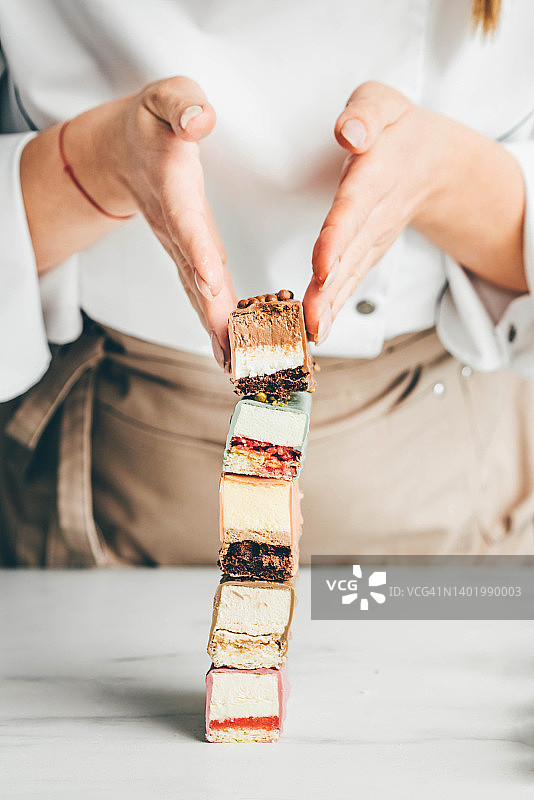 年轻女厨师展示各种蛋糕图片素材