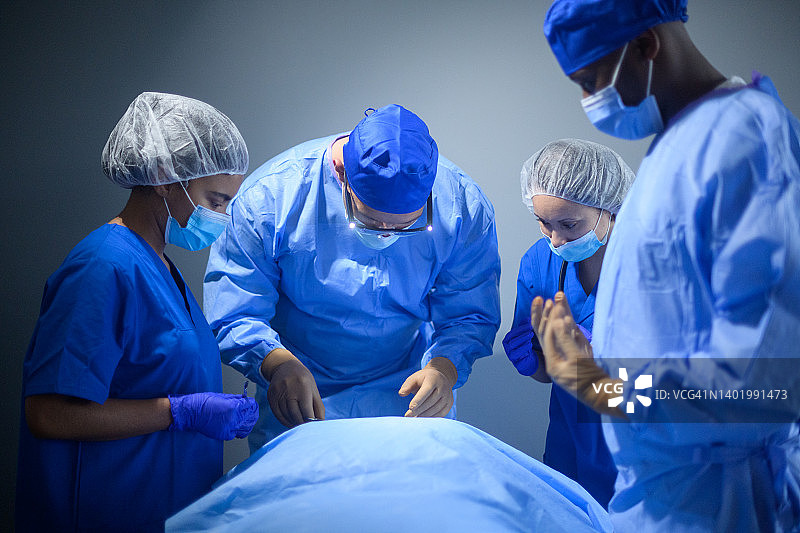 多元种族外科医生团队在手术室合作图片素材
