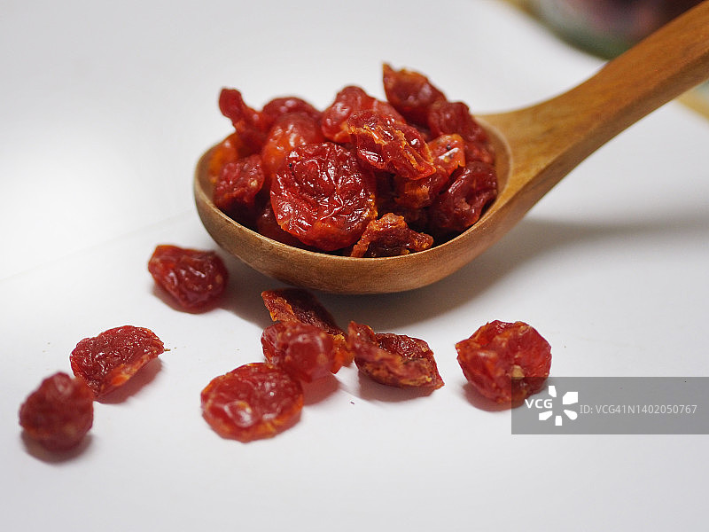 白色背景木勺中的西红柿干豆图片素材