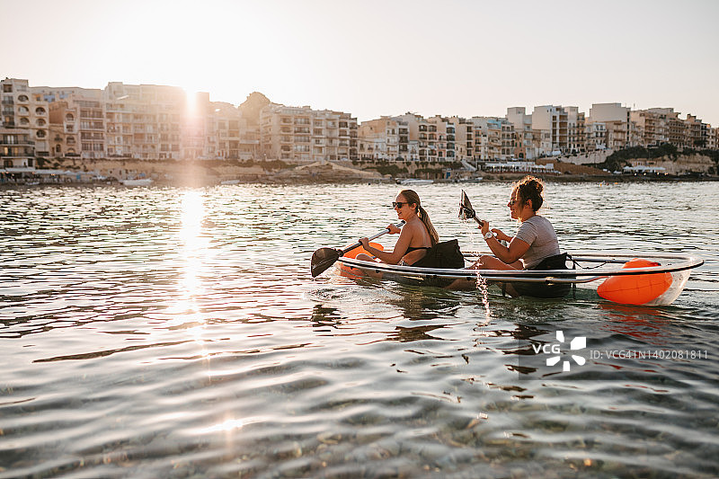 阳光下，自信的好友们一起海上划皮划艇图片素材