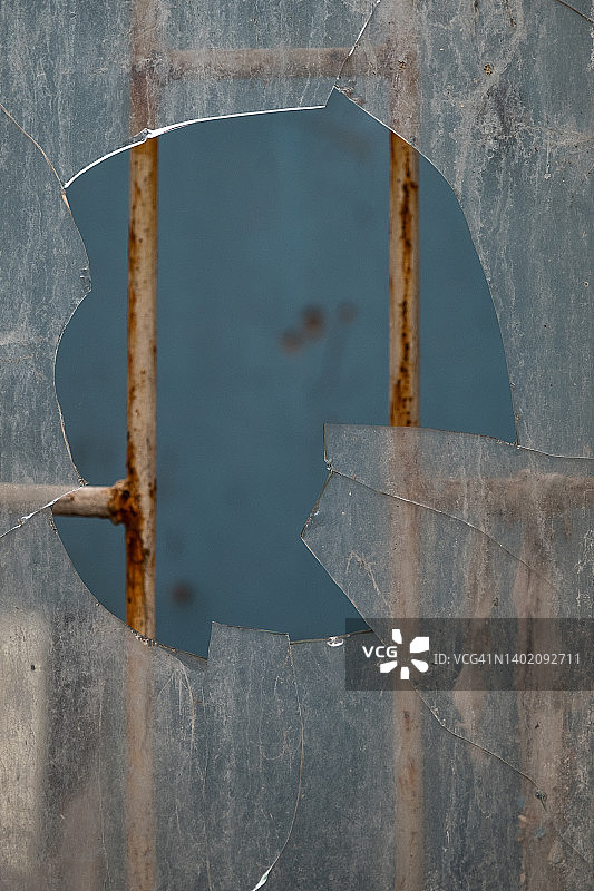 窗框中脏污的碎玻璃。 废弃的破旧建筑物或房屋。 轰炸建筑物造成的损坏，故意破坏的后果。图片素材