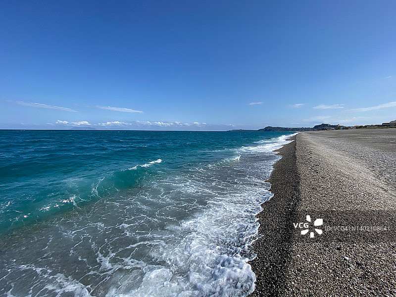 阳光明媚的黑色卵石海滩，意大利西西里岛图片素材