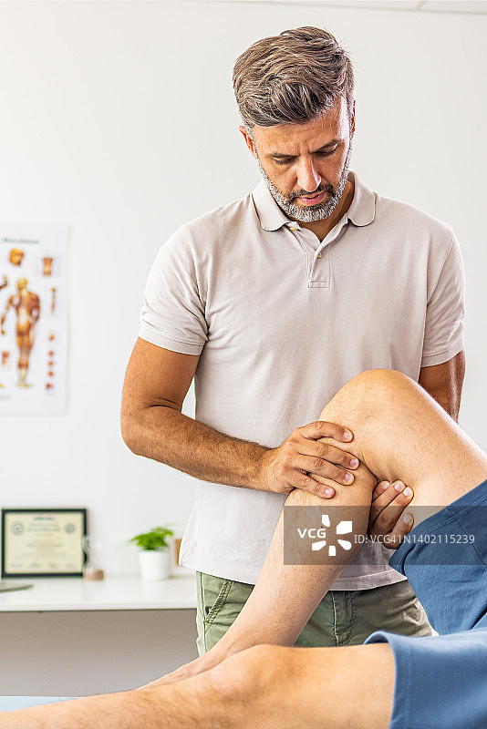 理疗师在诊所中心与运动员病人合作图片素材