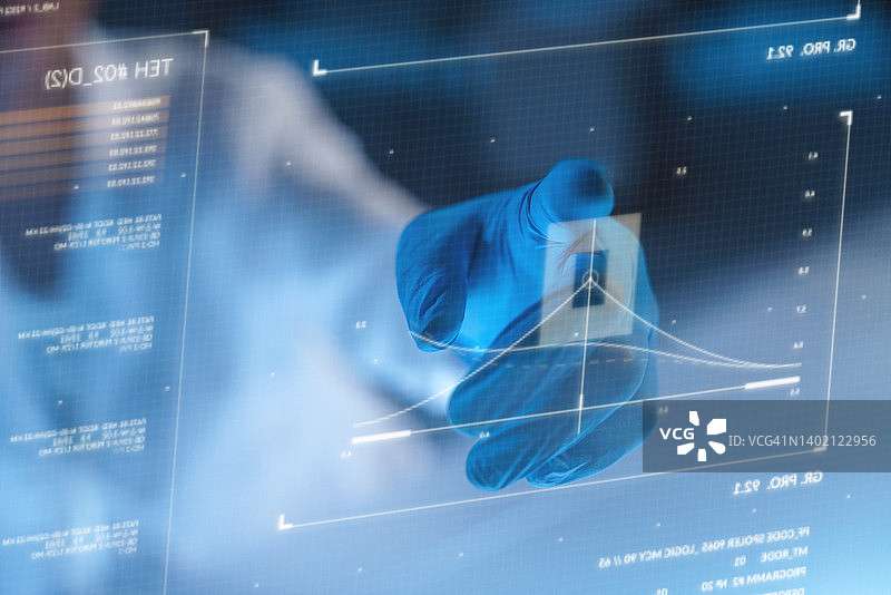 戴防护手套的手使用带有图表的未来科技抬头显示器屏幕图片素材
