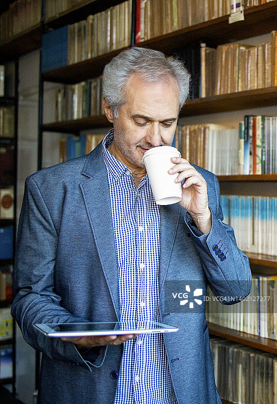 大学资深教授在图书馆查看学生统计数据图片素材