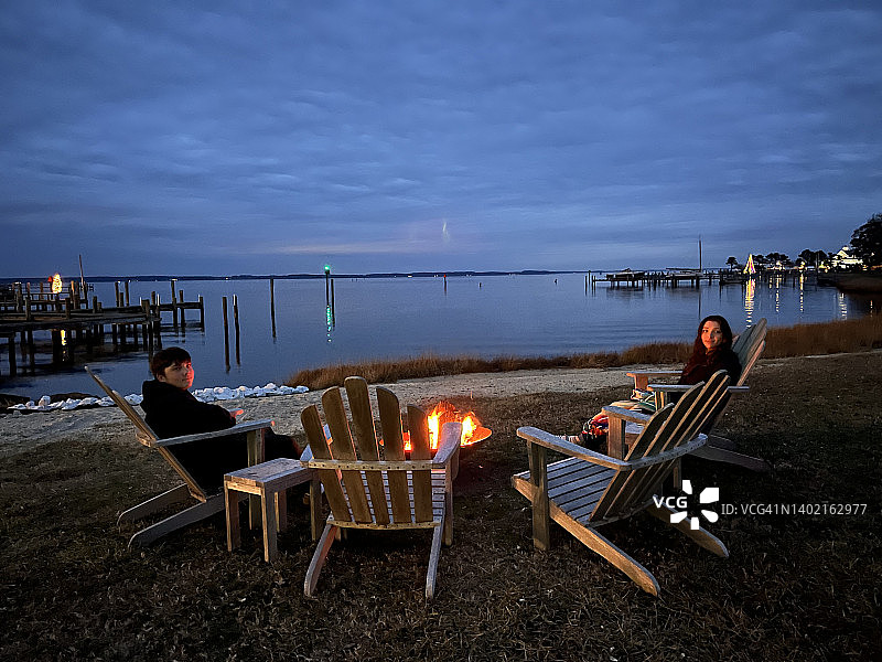 在蒂尔曼岛切萨皮克湾岸边，一家人围坐在篝火旁度周末图片素材