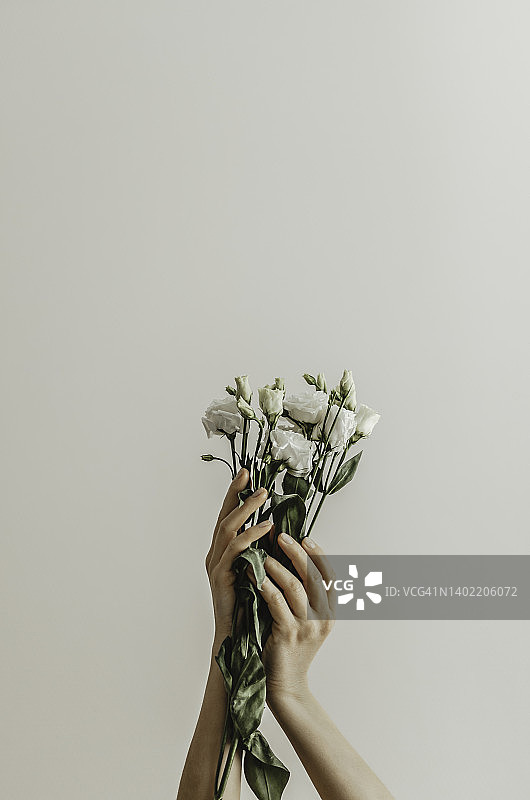 特写：手持白色花朵的精致女性图片素材