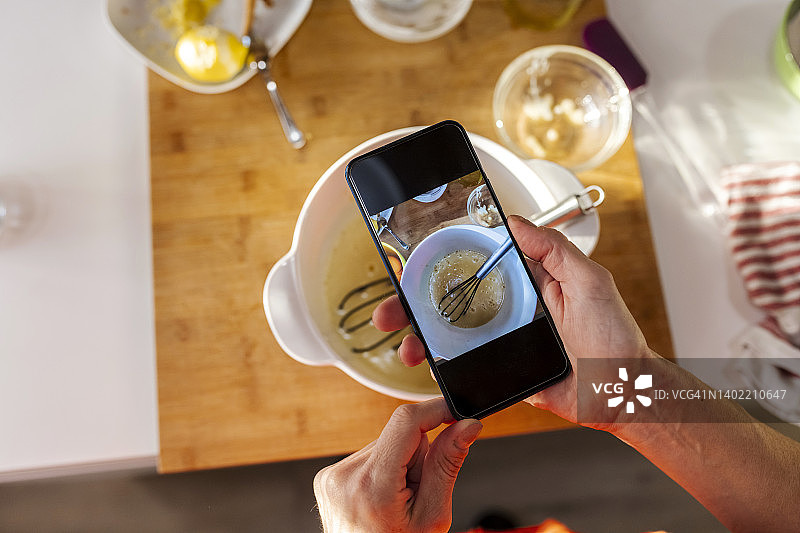 女人在厨房用手机拍摄食物图片素材