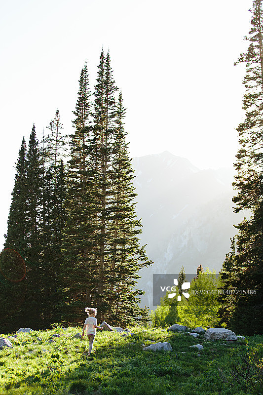 女孩在犹他州大棉白杨峡谷的阳光下行走图片素材