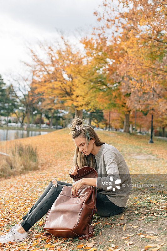 秋季坐在户外的身穿中性色服装的妇女图片素材