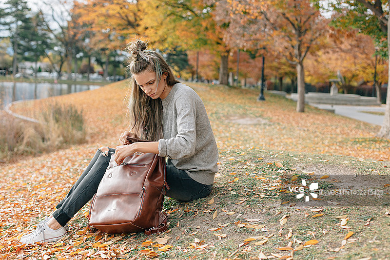 秋季坐在户外的身穿中性色服装的妇女图片素材