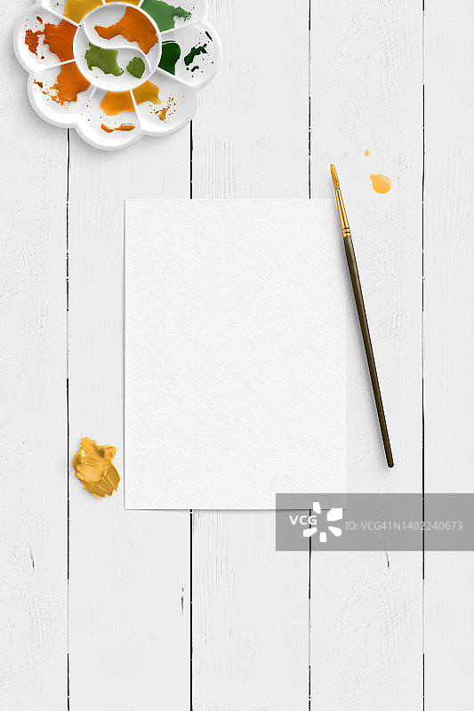 空白纸张与艺术家工作区俯视图，含水彩和画笔图片素材
