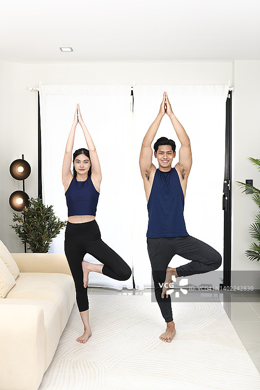 年轻夫妇在家练习瑜伽图片素材