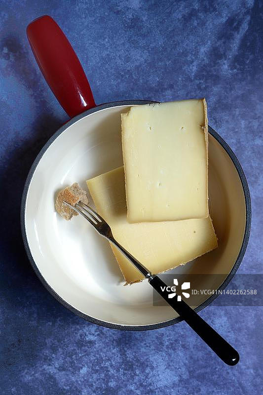 瑞士奶酪火锅食材：瓦什兰奶酪、格鲁耶尔奶酪和面包块叉子图片素材