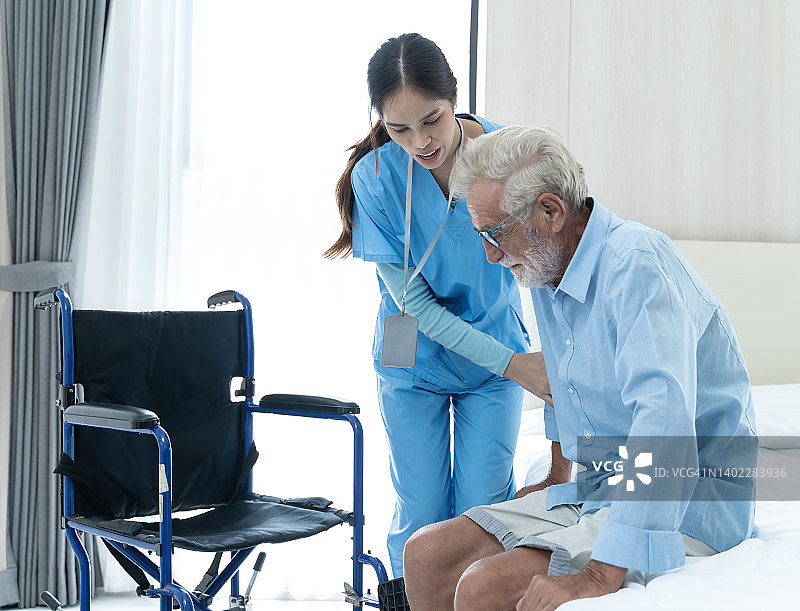 亚洲女护士在家中帮助坐轮椅的老年男性病人起床图片素材