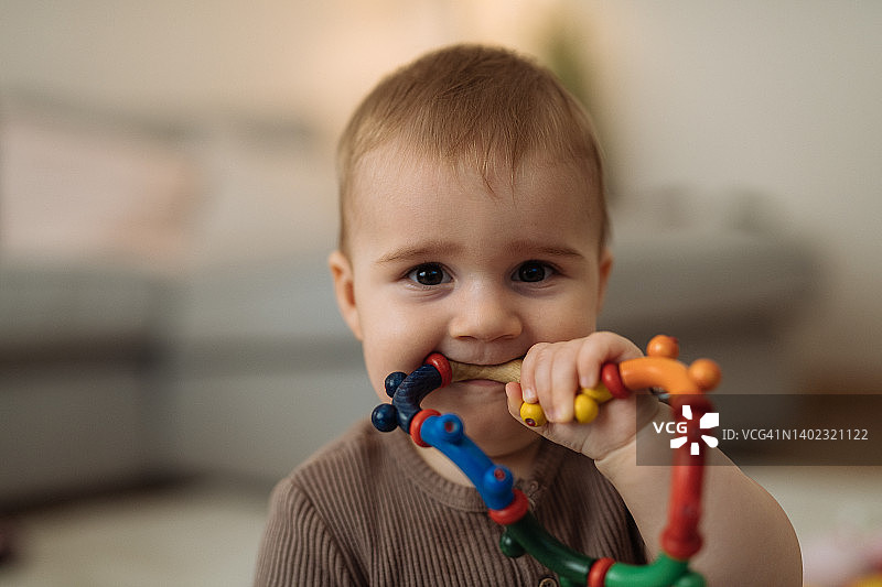 出牙的男宝宝咬玩具图片素材