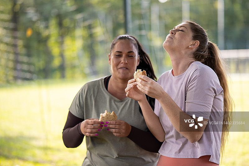 年轻女运动员休息并吃东西补充营养图片素材