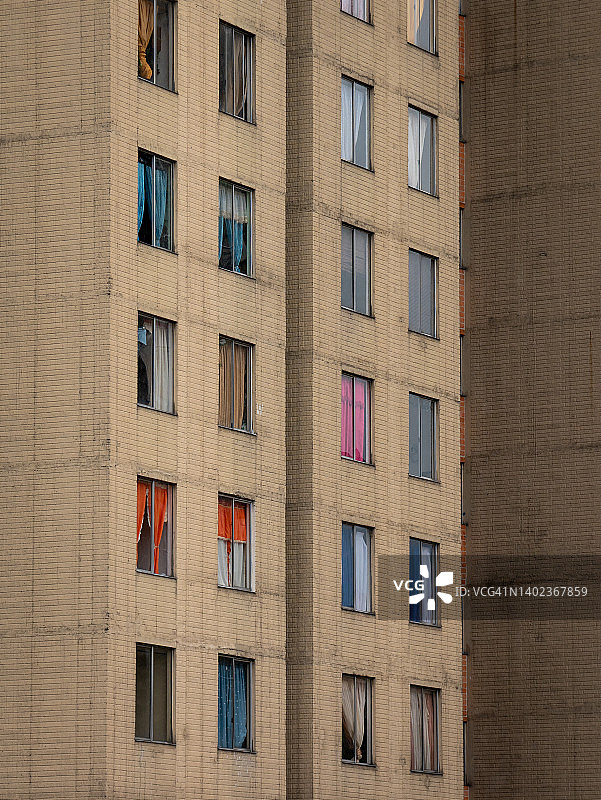 老城区破旧建筑窗户上的彩色窗帘图片素材