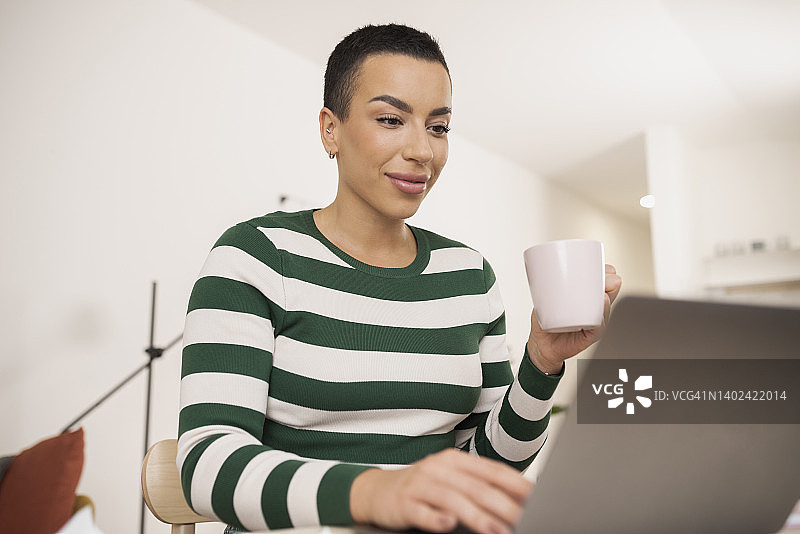 年轻女人喝咖啡进行线上工作图片素材