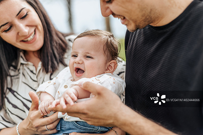 在公园里抱着男婴的家庭合影图片素材