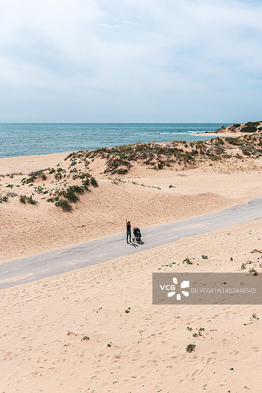 沙漠景观中推着婴儿车的母亲航拍图片素材