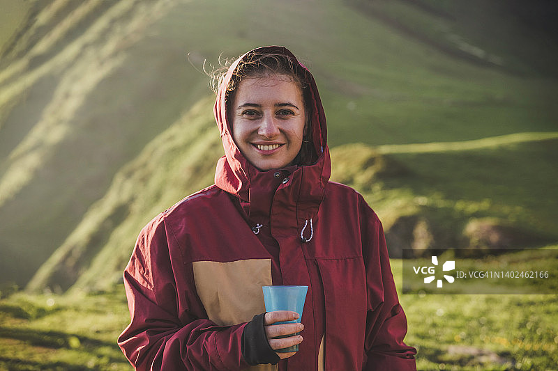 女游客在山区徒步旅行期间在休息站喝水图片素材